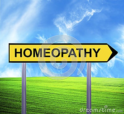 Conceptual arrow sign against beautiful landscape with text - HOMEOPATHY Stock Photo