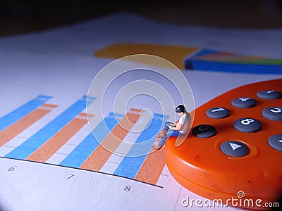 Top View, Conceptual Close Up Photo, Sitting Man at Orange E-Banking Token, controlling his business through Smartphone Stock Photo