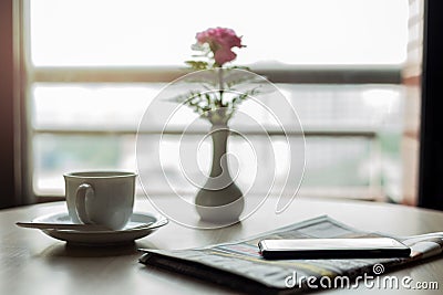 Conceptual cup of coffee with newspaper and cell phone on wooden Stock Photo