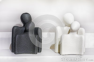 conceptual desktop contrasting black and white figurines of a woman and a man. Stock Photo