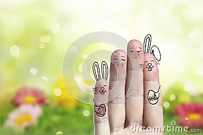 Conceptual easter finger art. Couple with a two bunnys are holding painted eggs Stock Photo