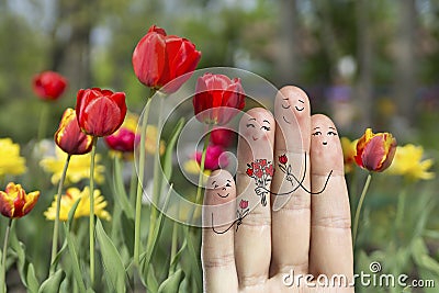 Conceptual family finger art. Father, son and daughter are giving flowers their mother. Stock Image Stock Photo