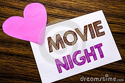 Conceptual hand writing text showing Movie Night. Concept for Wathing Movies written on sticky note paper, wooden wood background Stock Photo