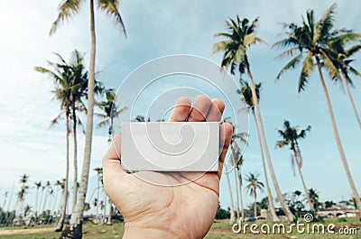 Conceptual image, cropped hand holding white frame canvas over blurred village background Stock Photo