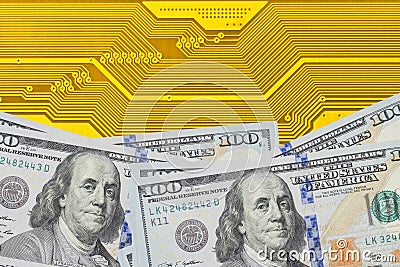 Conceptual image of power in digital and financial industry. Stack of dollar bills on electronic circuit board close up. Stock Photo