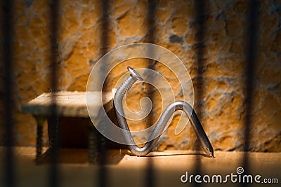 Conceptual jail photo with iron nail sitting behind bars Stock Photo