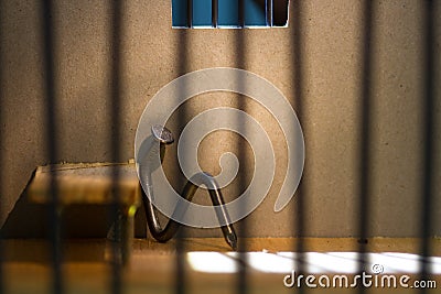 Conceptual jail photo with iron nail sitting behind bars Stock Photo