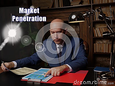 Conceptual photo about Market Penetration Male office workers with yellow shirt holding and writing documents on office desk Stock Photo