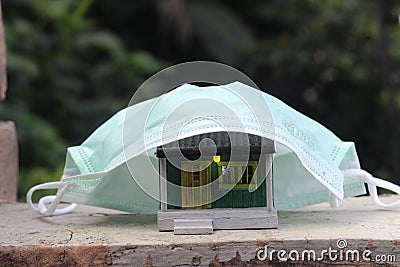 Conceptual Photo, Small Toy Scale HO Diorama, covered by light Green N95 Mask, Illustration for Stay Home Suggestion Stock Photo