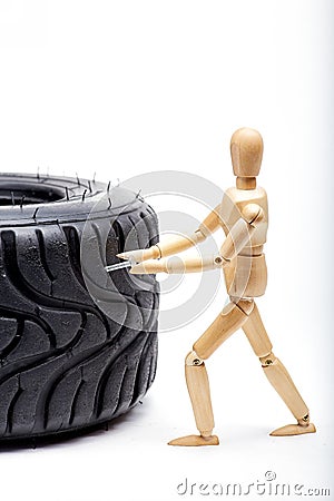 The concept of the workshop tire fitting. Miniature mechanic repairing dusty car wheel, close up Stock Photo