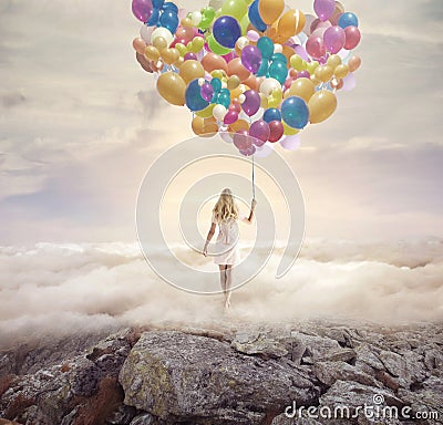 Conceptual picture of a woman holding hundreds of balloons Stock Photo