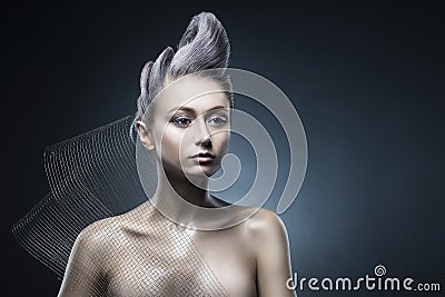 Conceptual portrait of beautiful naked shoulders vanguard hairstyle metallic colour hair girl wearing steel construction armature Stock Photo