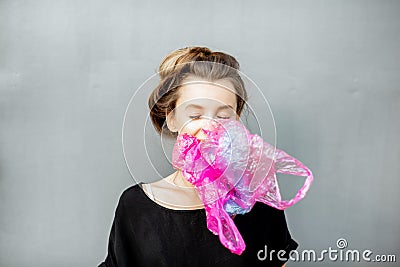 Conceptual portrait of a woman suffocating of plastic bags Stock Photo