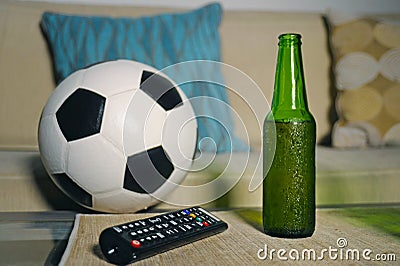 Conceptual watching football game at sofa on television with beer bottle and popcorn bowl in friends enjoying soccer game TV Stock Photo