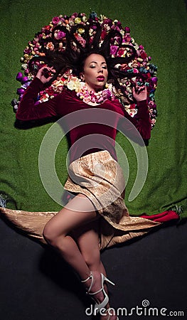 Conceptual studio portrait girl. Artificial flowers and a green background Stock Photo