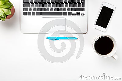 Conceptual workspace or business concept. Laptop computer with plant in a pot, cup of coffee blue pen and modern mobile cell phone Stock Photo