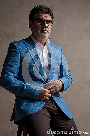 Concerned businessman adjusting his jacket and looking to the side Stock Photo