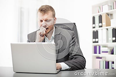 Concerned businessman working at his desk Stock Photo