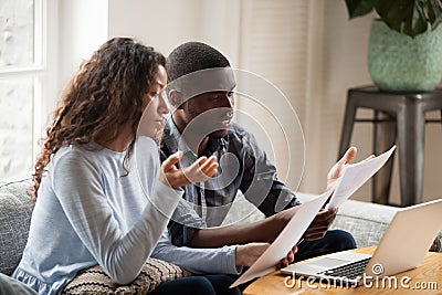 Concerned black couple read bills considering paperwork at home Stock Photo