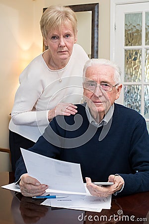 Portrait Of Concerned Senior Couple Reviewing Domestic Finances Stock Photo