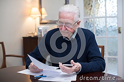 Concerned Senior Man Reviewing Domestic Finances Stock Photo