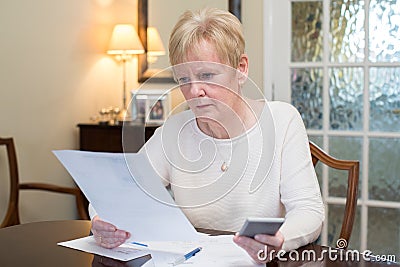 Concerned Senior Woman Reviewing Domestic Finances Stock Photo