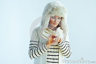 Woman having cold allergy against winter light blue background Stock Photo