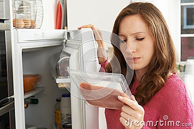 Concerned Woman Looking At Pre Packaged Meat Stock Photo