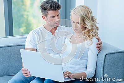 Concerned young couple using a laptop computer Stock Photo