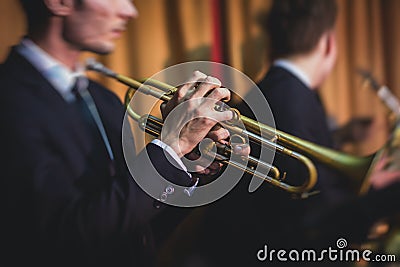 Concert view of a male trumpeter, professional trumpet player with vocalist and musical during jazz band performing music Stock Photo