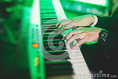 Concert view of a musical keyboard piano player during musical jazz band performing in the background Stock Photo