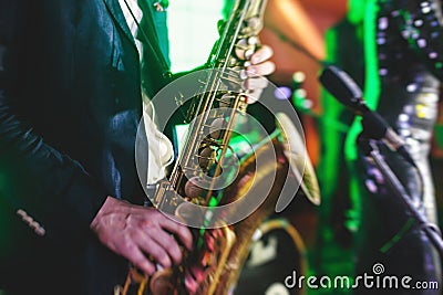 Concert view of a saxophone player with vocalist and musical jazz band in the background Stock Photo