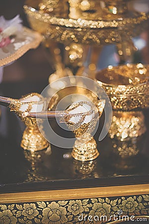 Conch shell in gold decoration. Conch shell us used to pour blessed water during the wedding ceremony. Vintage filter Stock Photo