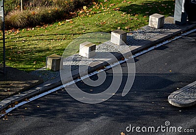 concrete barriers to protect a nice lawn cubes on a paved Stock Photo