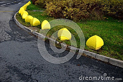 concrete barriers to protect a nice lawn cubes on a paved sidewalk. Stock Photo
