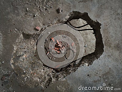 Concrete construction, hole in the floor, broken bricks and concrete debris on the floor below Stock Photo