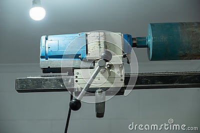 Concrete coring drill bolted to interior breeze block wall Stock Photo