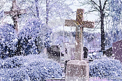 Concrete cross with crucifix in cemetery in winter Stock Photo