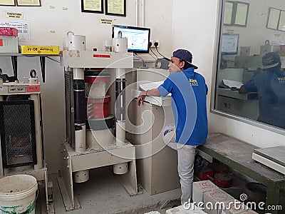 Concrete cube strength compression test at the laboratory using compression machine. Editorial Stock Photo