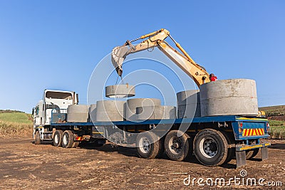 Concrete Drain Pipes Unloading Truck Stock Photo