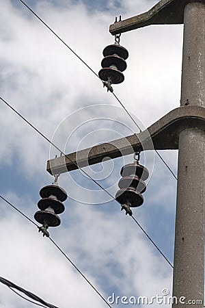 Concrete electrical power line utility pole with ceramic insulators and three connected wires.. Stock Photo