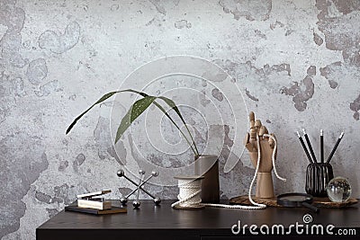 Concrete interior of home office with desk, leaves and office accessories. Grey concrete wall. Home decor. Template Stock Photo