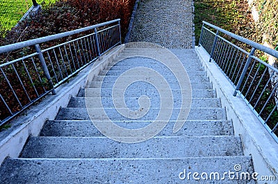 Concrete long staircase with long and short pieces of stairs and ramps made of cobblestone granite paving blocks. packing short ga Stock Photo