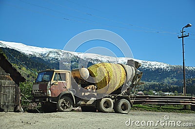 Concrete mixer on the background of beautiful mountains Editorial Stock Photo