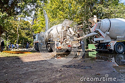 Concrete mixer at the construction site, pouring concrete from one mixer to other with pump for concrete Editorial Stock Photo