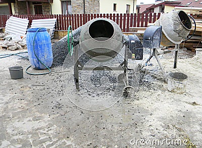 Concrete mixers with pouring cement on house construction site Stock Photo