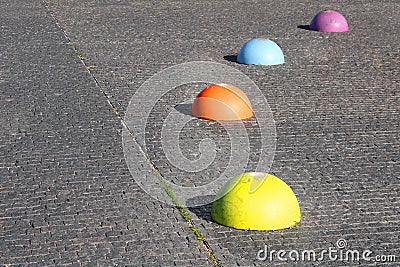 Concrete multi-colored hemispheres restricting the entry of cars Stock Photo