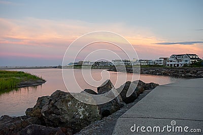 A Concrete Path With an Orange and Blue Sunset Sky Behind It at the North Wildwood Sea Wall in New Jersey Stock Photo