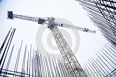 Concrete pillars on industrial construction site. Building of skyscraper with crane, tools and reinforced steel bars Stock Photo