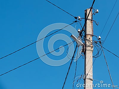 Concrete pole with lantern and lots of electric wires Stock Photo